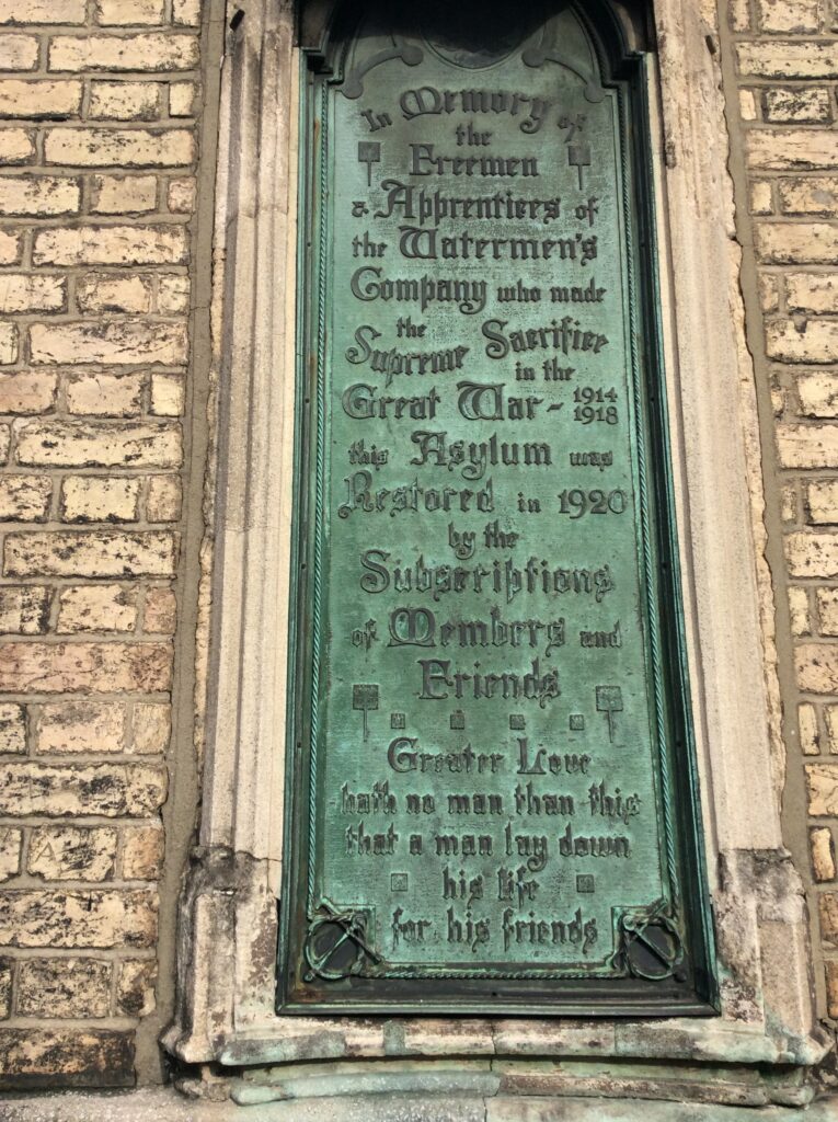 A copper war memorial set into a brick wall. It reads:
In Memory of the Freemen and Apprentices of the Watermen's Company who made the Supreme Sacrifice in the Great War - 1914 - 1918

The Asylum was restored in 1920 by the subscriptions of members and friends.

Greater love hath no man than this that a man lay down his life for his friends. 